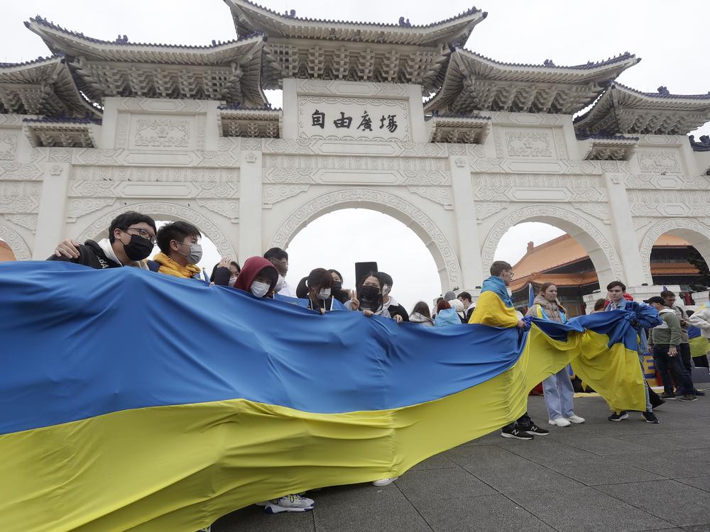 A group of Ukrainian people in Taiwan and supporters hold a Ukraine national flag  during a protest, marking one year since the Russian invasion of Ukraine, at Liberty Square in Taipei, Taiwan, Saturday, Feb. 25, 2023.