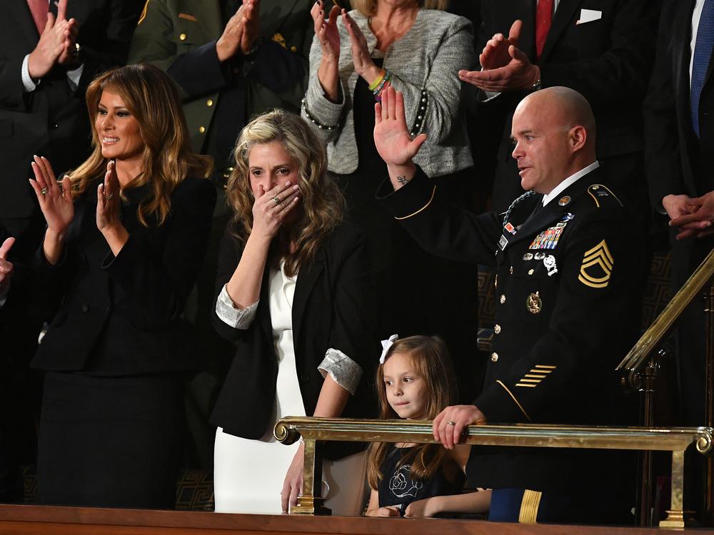 Sgt. Townsend Williams (at right) waves after returning from deployment in Afghanistan, surprising his wife Amy during the 2020 State of the Union address.