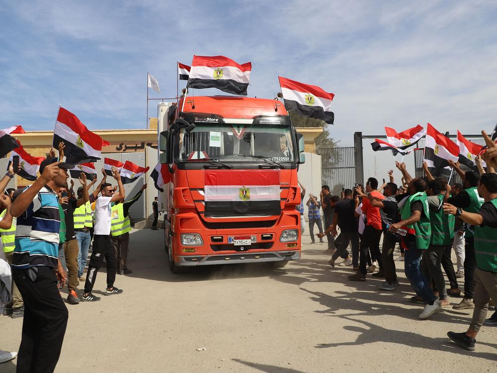 Egyptian aid workers celebrate as an aid truck crosses back into Egypt through the Rafah border crossing with the Gaza Strip on October 21, 2023.