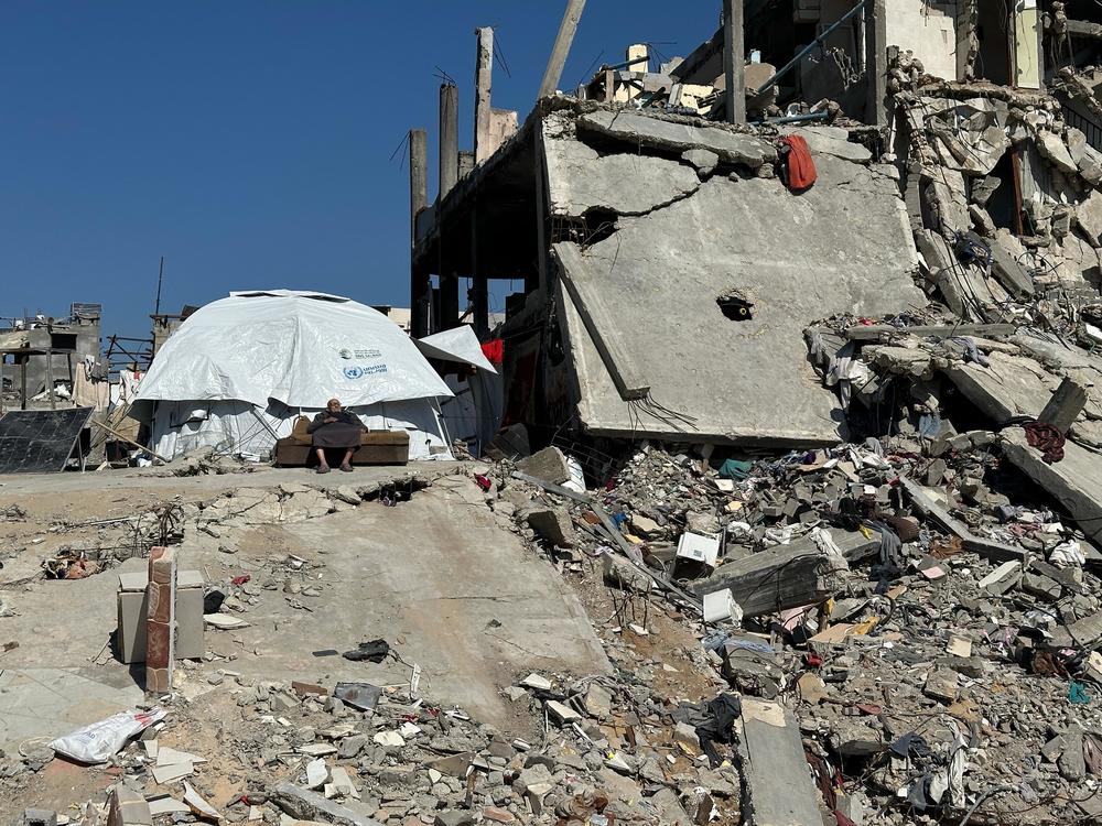 A man sits in front of a tent and his demolished home in Jabalia in northern Gaza. Feb. 27.