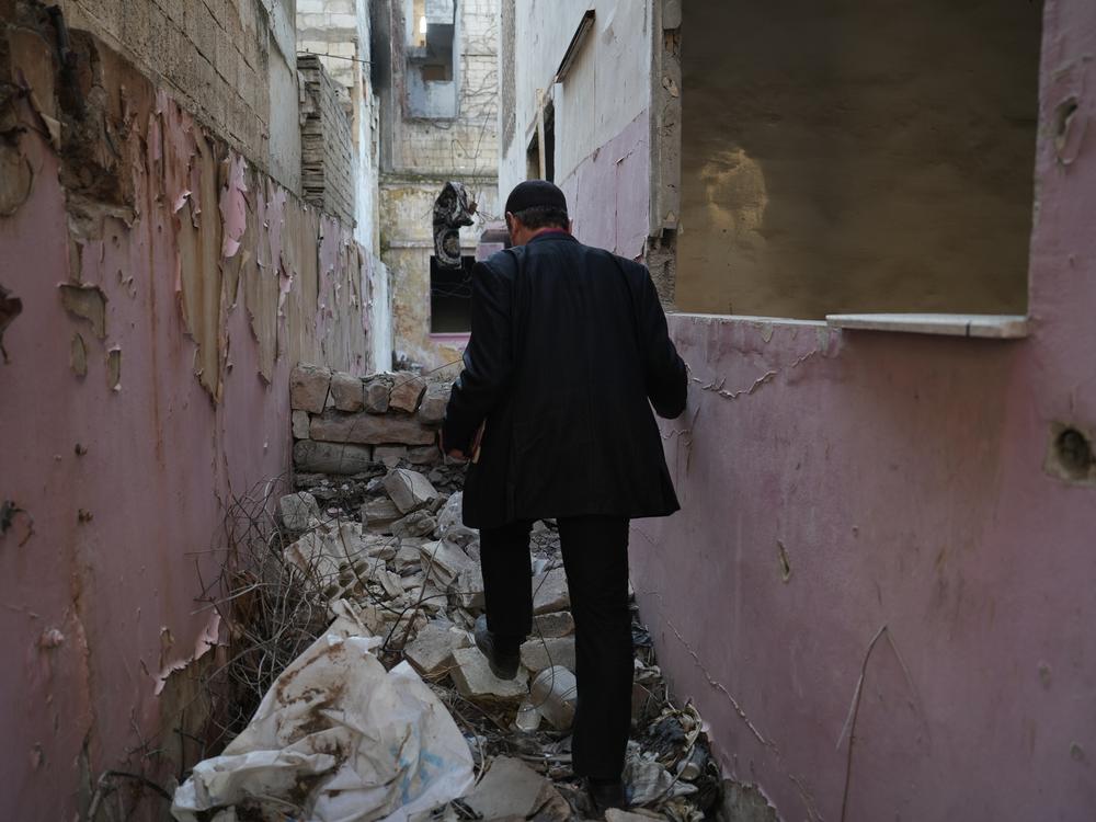 Ayman al-Masri wanders through the remains of his old home, where he first met Sarout, in Homs, Syria, on Feb. 1.