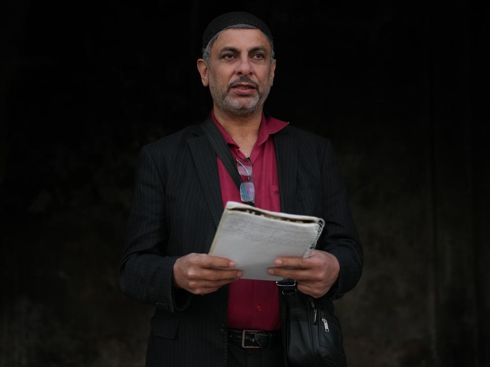 Ayman al-Masri carries a notebook where he hand-wrote songs, in Homs, Syria, on Feb. 1.