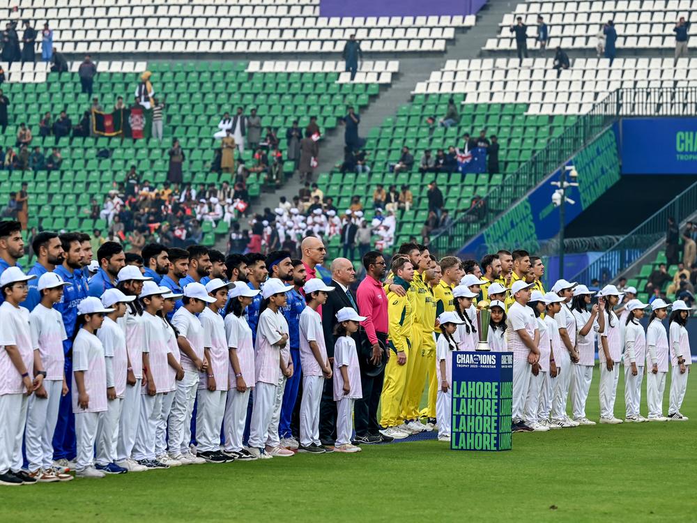 Afghanistan's and Australia's players stand for the national anthem before the start of the ICC Champions Trophy one-day international cricket match between Australia and Afghanistan at the Gaddafi Stadium in Lahore on Feb. 28.