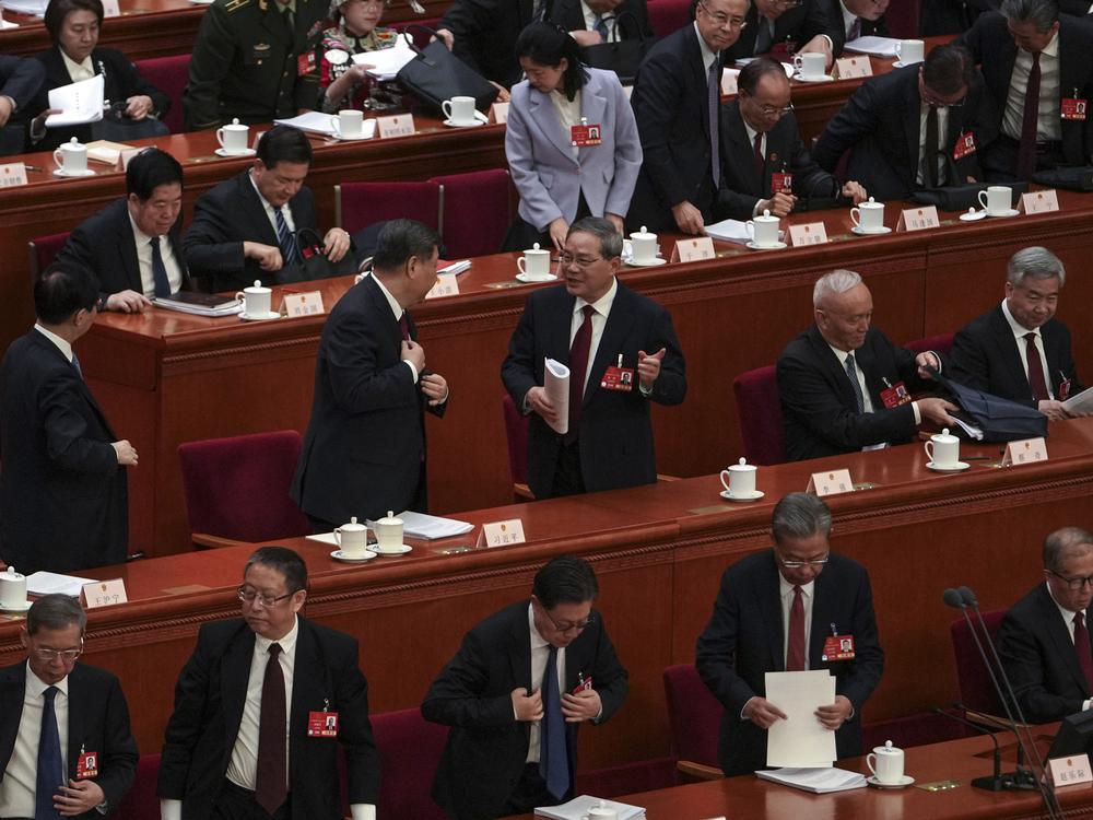 Chinese President Xi Jinping, center left, chats with his Premier Li Qiang as leaders and delegates prepare to leave after attending the opening session of the National People's Congress held at the Great Hall of the People in Beijing on Wednesday.
