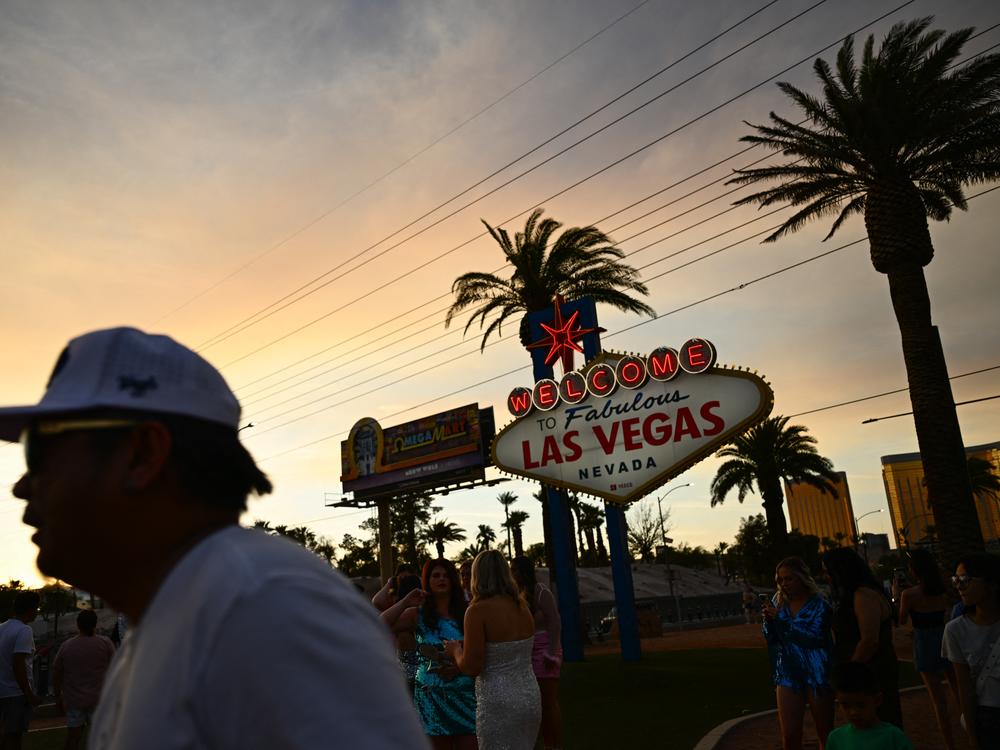 People take pictures with the Las Vegas sign in that city on July 29, 2023. Tourism industry leaders warn that recent actions by the Trump administration may be causing a drop in Canadians traveling to the U.S.