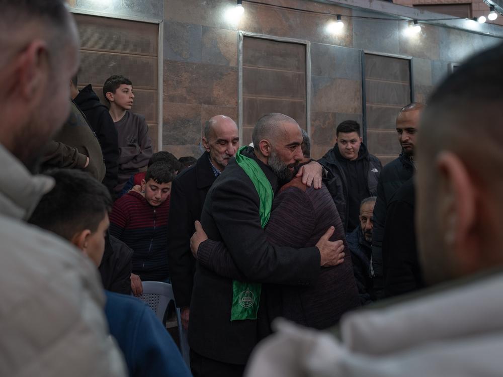 Ashraf Zughayer (center), a Palestinian who was released from Israeli prison during a ceasefire between Israel and Hamas, hugs his family in their home in Kfur Aqab, East Jerusalem, on Jan. 25.