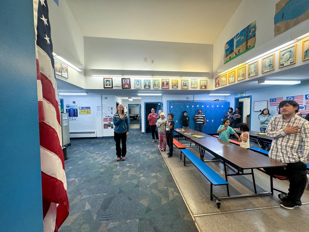 Students start their day with the Pledge of Allegiance in Sleetmute, where the school's roof has been leaking for longer than they've been alive.
