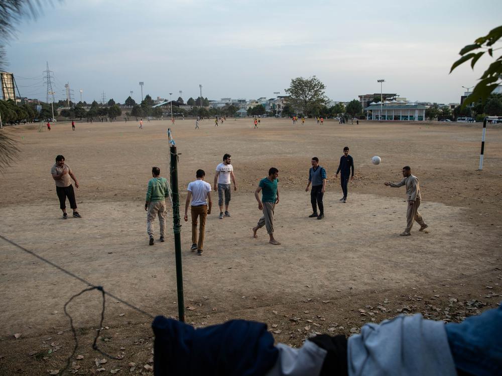 Men play volleyball in an Islamabad neighborhood with a sizable Afghan population, including families with U.S. resettlement cases.