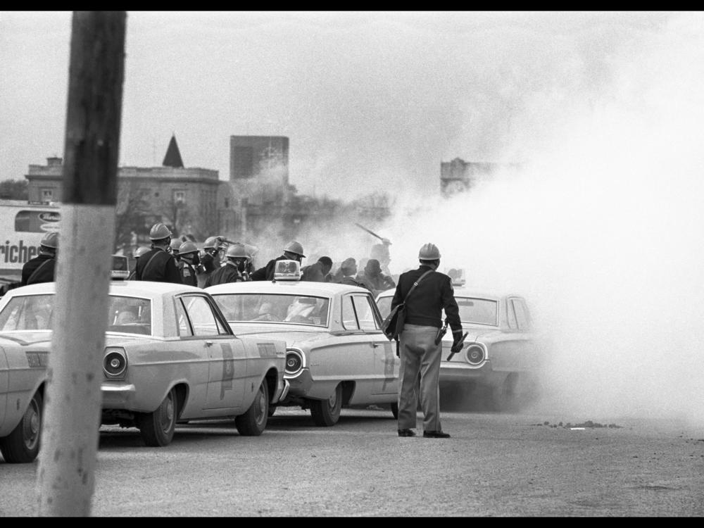 Troopers continue their assault on retreating marchers with tear gas and billy clubs.