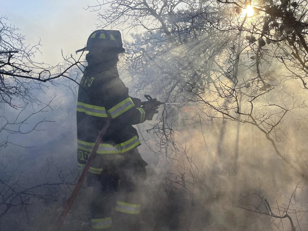 Firefighters respond to a brush fire in Suffolk County in New York's Long Island on Saturday.