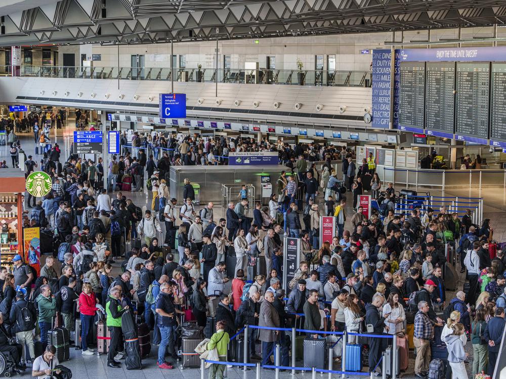 People queue in long lines in departure hall C at Rhine-Main Airport, Frankfurt, Germany on Sunday, a day ahead of a planned strike across Germany amid new contract negotiations.