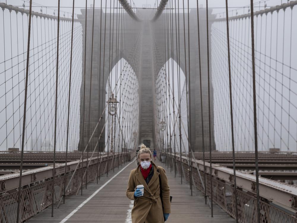 <strong>March 20, 2020:</strong>  A woman wears a mask while walking over the Brooklyn Bridge, as a COVID-19 outbreak rocks New York City.