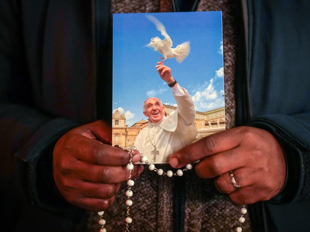 A priest holds a photograph of Pope Francis during the nightly rosary prayer service in St Peter's Square on Thursday, March 6 in Vatican City.