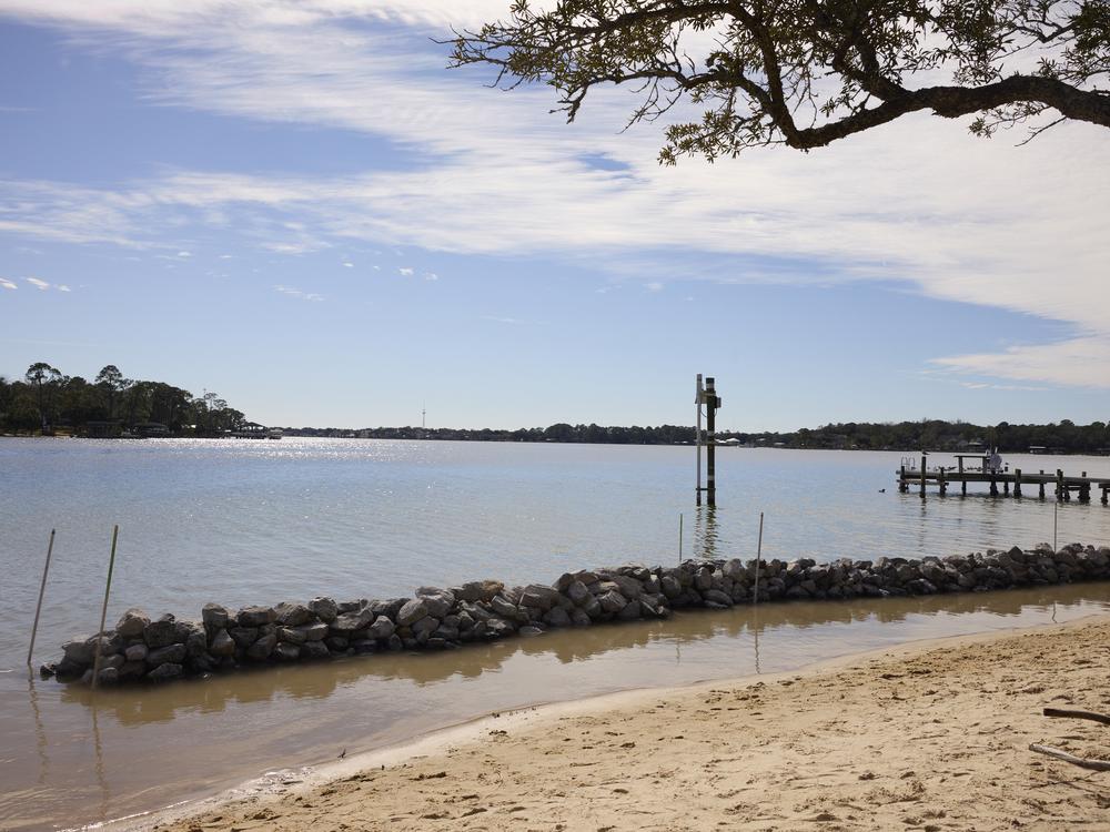 A 50-foot rubble barrier peeks above the water at low tide at the end of the Force Blue project.
