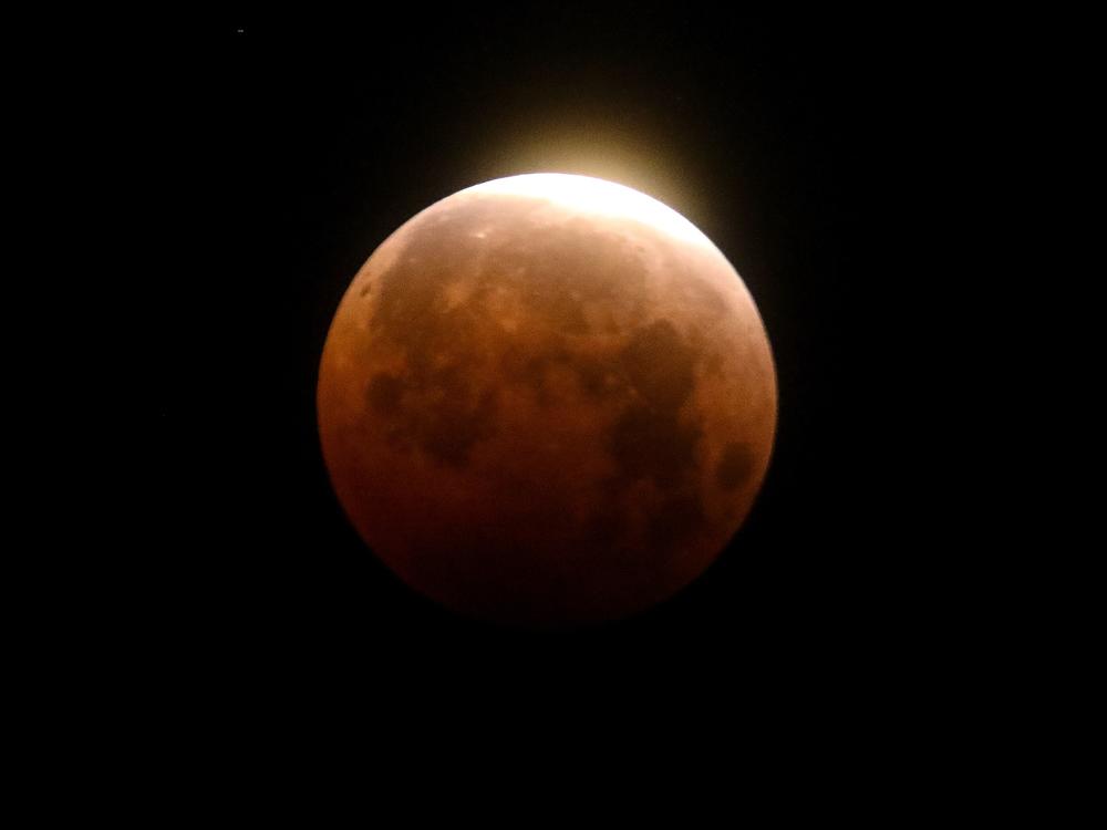 Light shines from a total lunar eclipse over Santa Monica Beach in California in 2021.