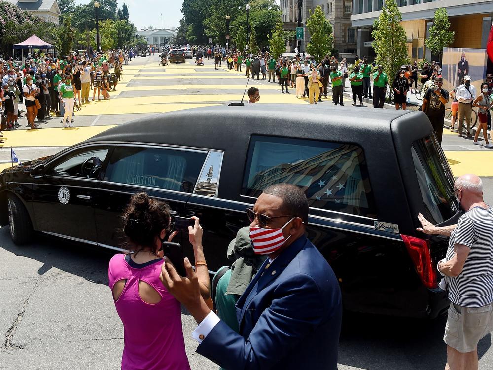 People gather at Black Lives Matter Plaza to watch the funeral procession for congressman and civil rights leader John Lewis on July 27, 2020.