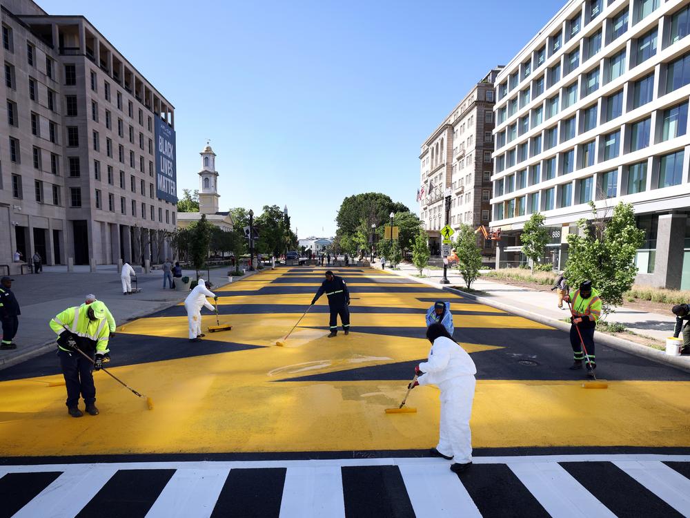 City workers repaint Black Lives Matter Plaza on May 13, 2021.