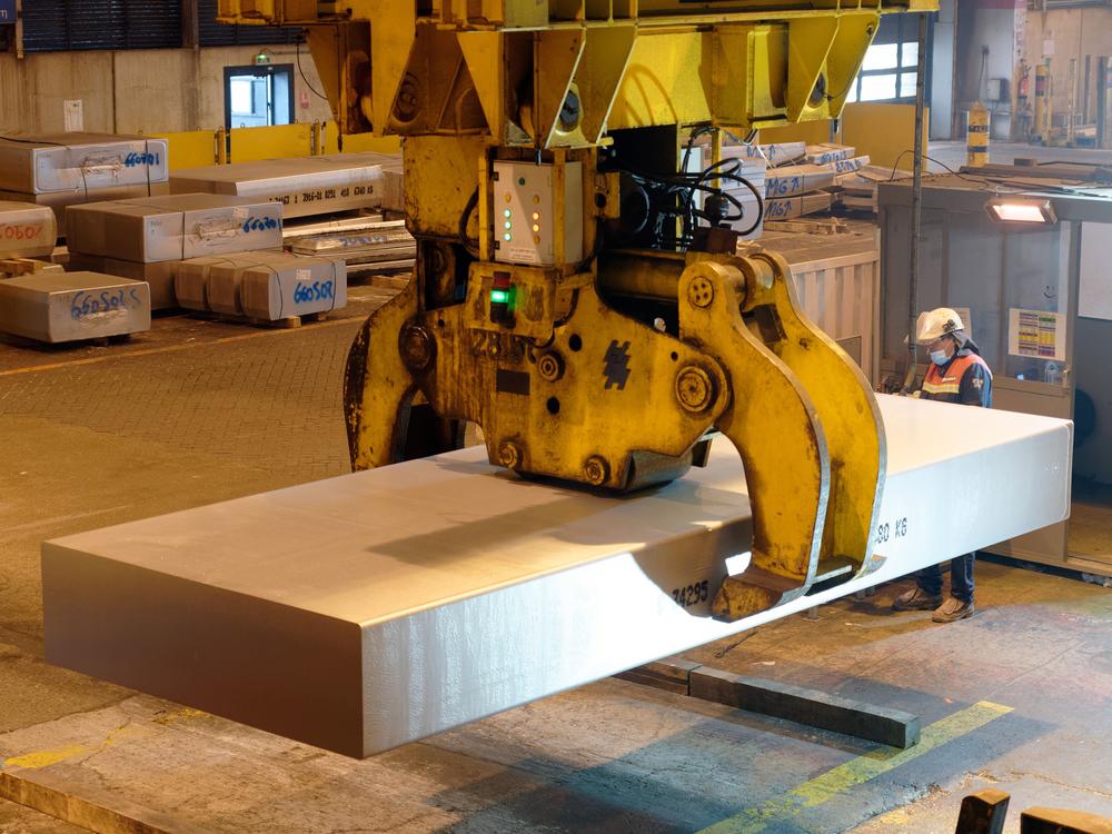 A worker manipulates a block of aluminum in a French smelter in 2022. President Trump has increased tariffs on imported aluminum from 10% to 25%, while also removing exceptions from tariffs on steel. Both metals are crucial raw materials for the automotive sector.