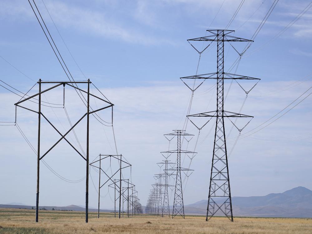 Electrical transmission lines run through grass lands to power Meta's Facebook data center in Eagle Mountain, Utah. The data center is a complex of five large buildings each over four football fields long and totaling 2.4 million square feet.