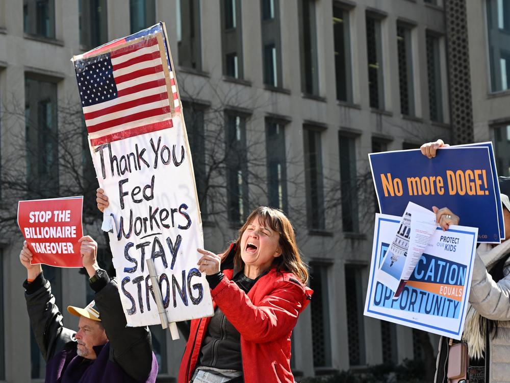 Protesters hold signs in solidarity at a rally in support of federal workers at the Office of Personnel Management in Washington, D.C., on March 4.