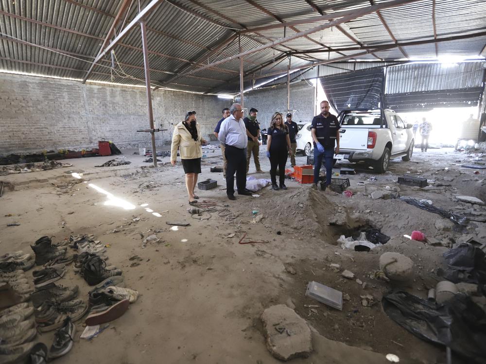 This photo released by the Jalisco State Attorney General's Office shows investigators inspecting the Izaguirre Ranch where skeletal remains were discovered in the municipality of Teuchitlan, Mexico on Tuesday.