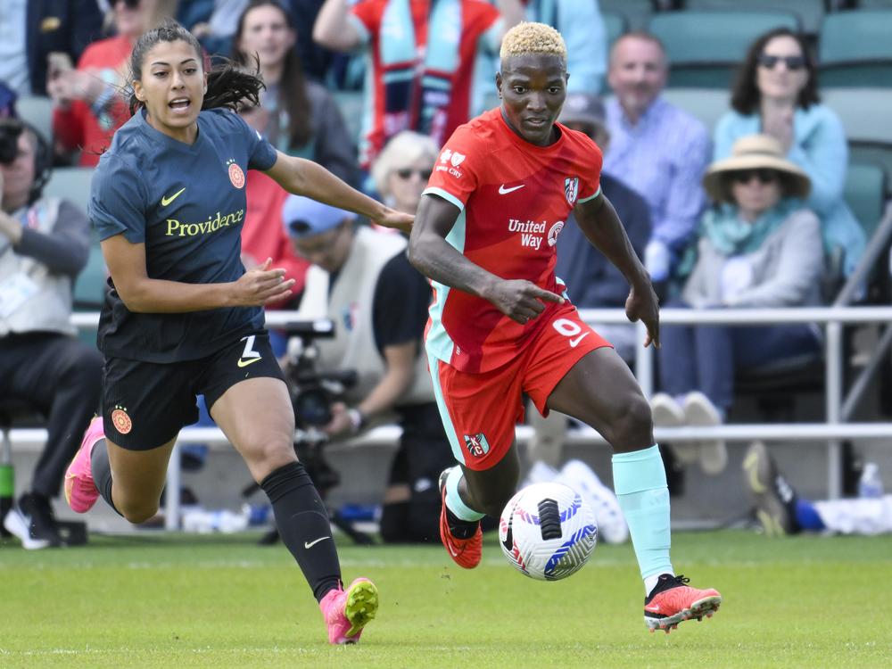 Kansas City Current forward Temwa Chaŵinga (right) and Portland Thorns FC defender Reyna Reyes chase after the ball during an NWSL soccer match at CPKC Stadium in Kansas City, Mo.,  on March 16, 2024.