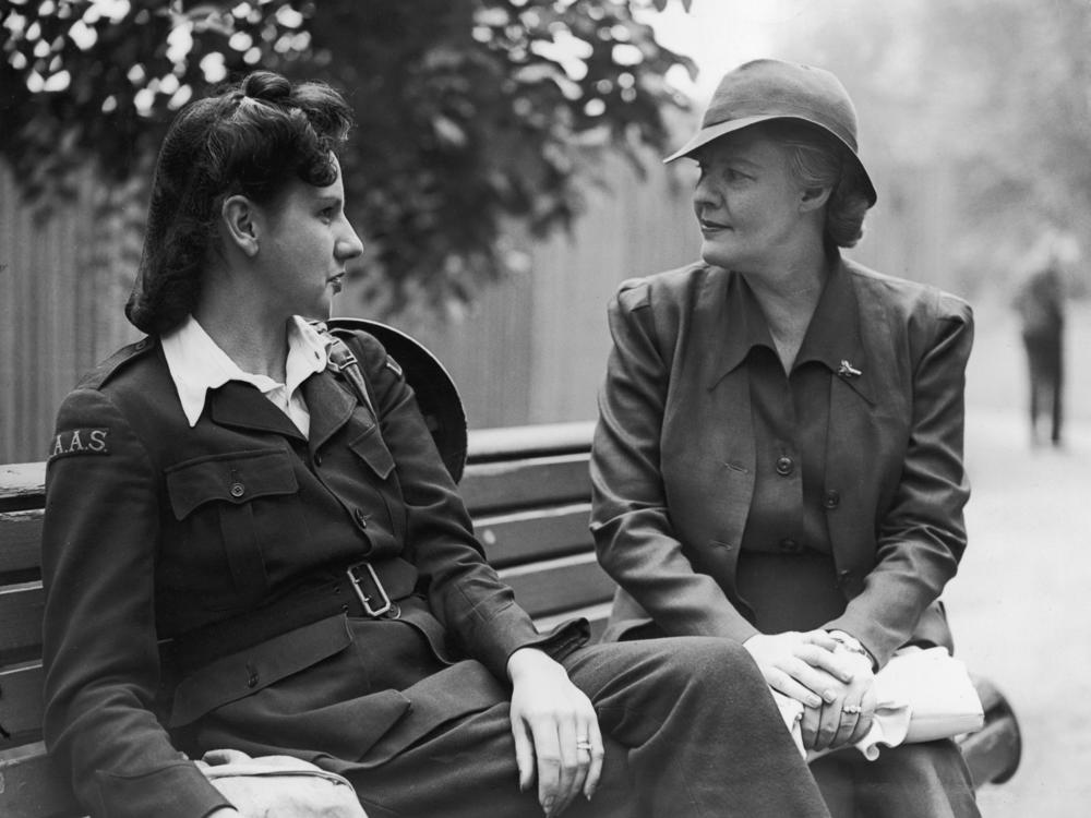 Thompson (right) speaks with an ambulance driver on a bench in London.