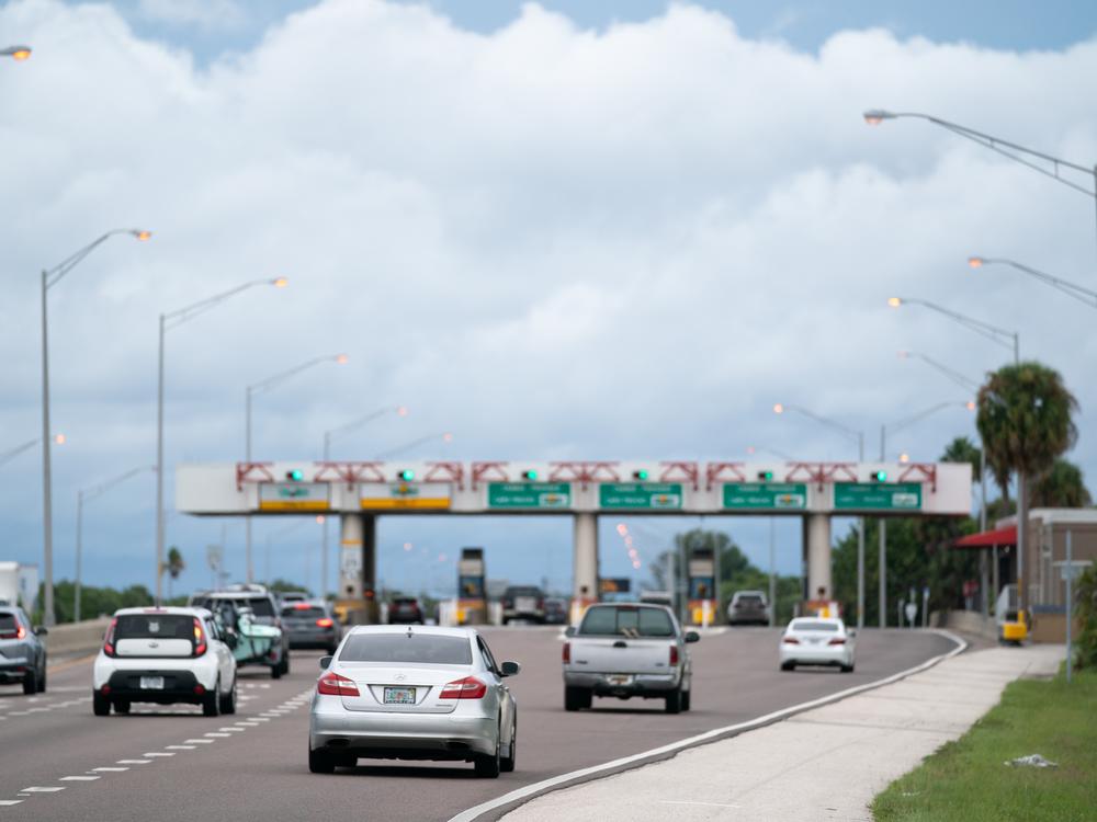 Motorists pass through a toll plaza near St. Petersburg, Florida. Bogus text messages threatening phone users with unpaid toll fees have spread rapidly — in part because scammers try to benefit from trends in travel and congestion pricing, an expert tells NPR.