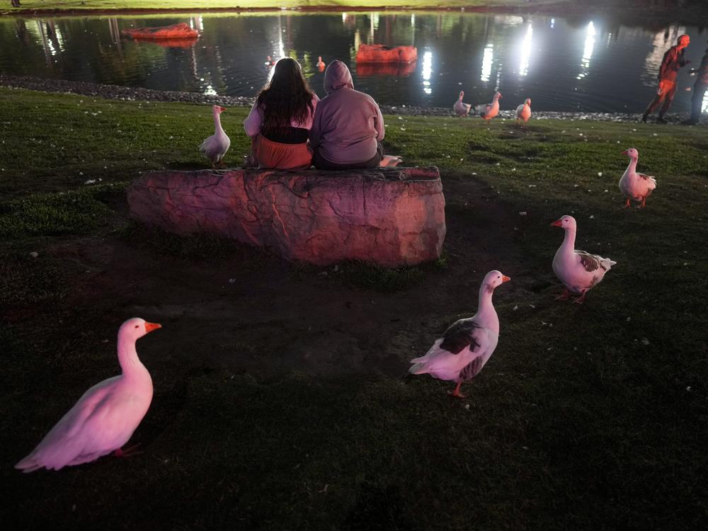 People sit outside the planetarium to watch the total lunar eclipse on Friday in Buenos Aires, Argentina.
