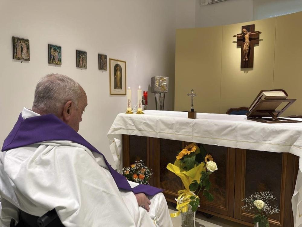 In this photo released by the Vatican, Pope Francis is seen praying inside Rome's Gemelli Hospital on Sunday.
