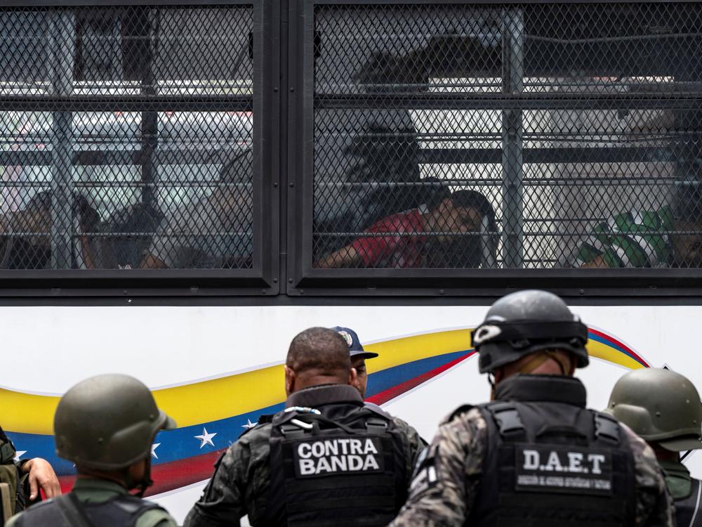 Members of the Bolivarian National Guard (GNB) stand guard as inmates aboard a bus are transferred outside the Tocoron prison in Tocoron, Aragua State, Venezuela, on September 20, 2023.
