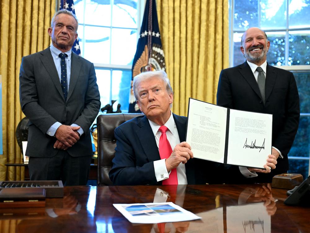 President Trump holds an executive order, alongside Secretary of Health and Human Services Robert F. Kennedy Jr. (left) and Commerce Secretary nominee Howard Lutnick, in the Oval Office on Feb. 25. Trump signed an executive order on the supply of copper and foreign copper in the American market, charging Lutnick with looking at a process to potentially impose tariffs or trade barriers.