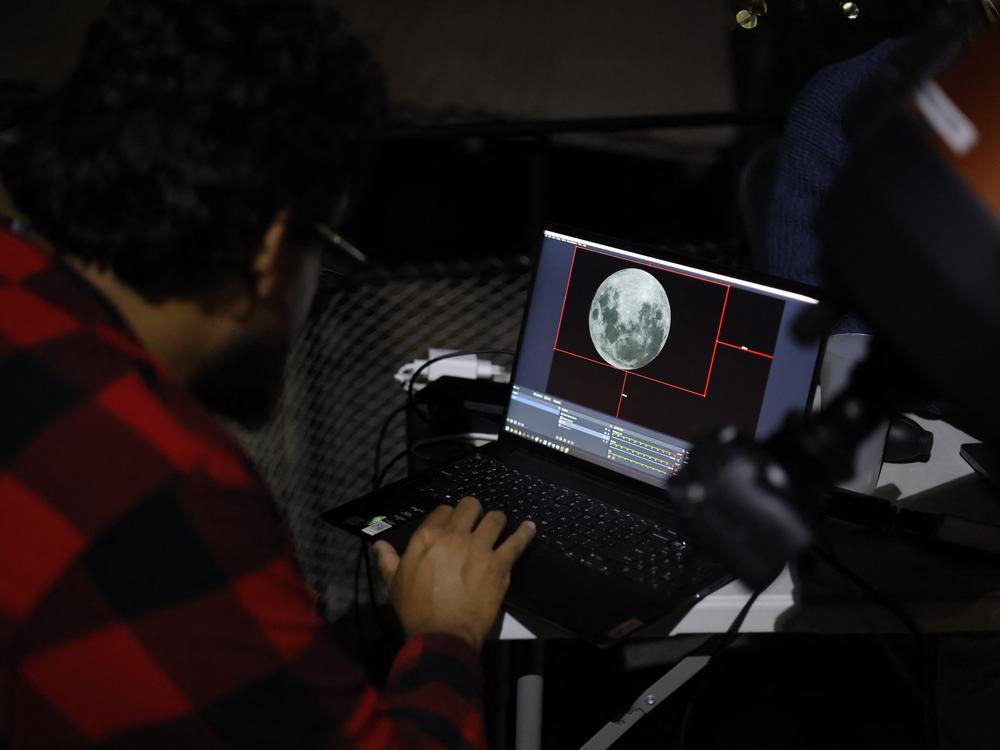 Scientists look at the moon displayed on a screen at the Foster Observatory in Santiago on Friday, prior to the lunar eclipse.