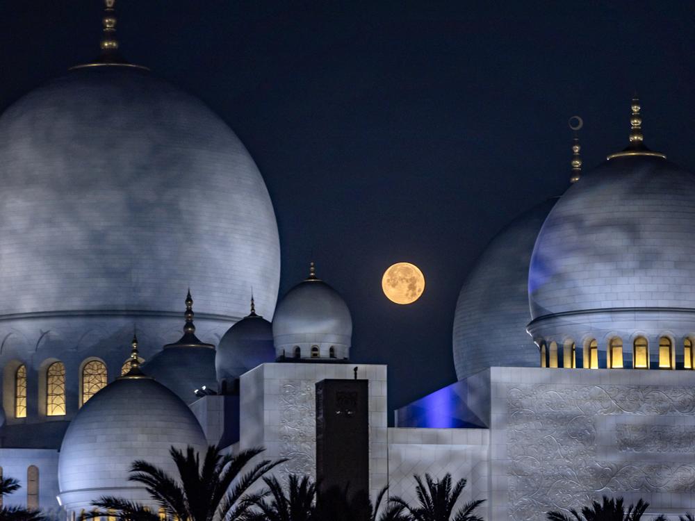 The setting moon is pictured over the Sheikh Zayed Grand Mosque in Abu Dhabi on Friday during Islam's holy fasting month of Ramadan.