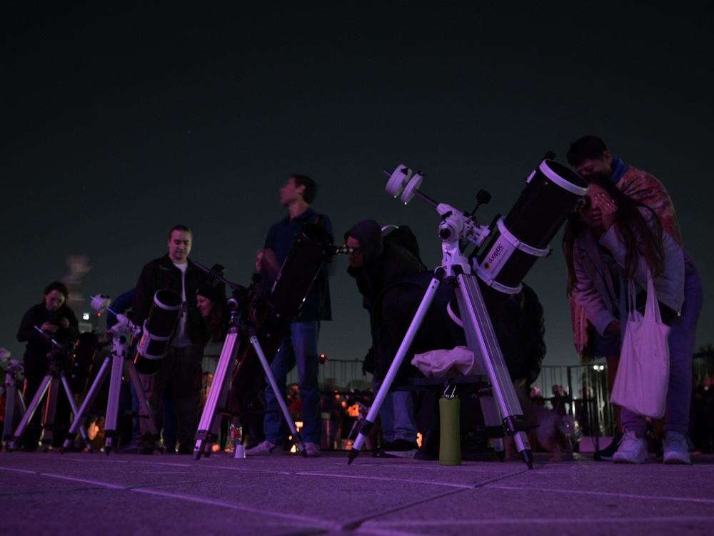 Skygazers watch the full moon eclipse at Galileo Galilei Planetarium in Buenos Aires on Friday.