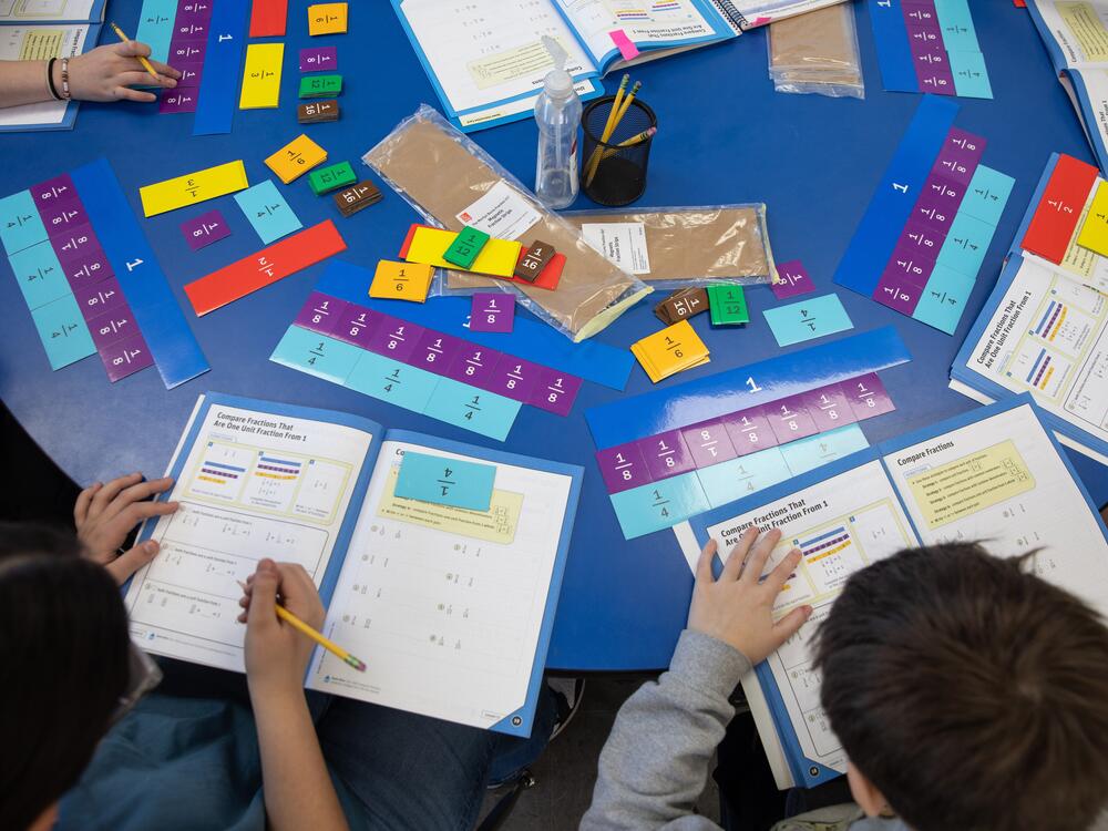 Students use fraction cut-outs to help them visualize similar values with different denominators.