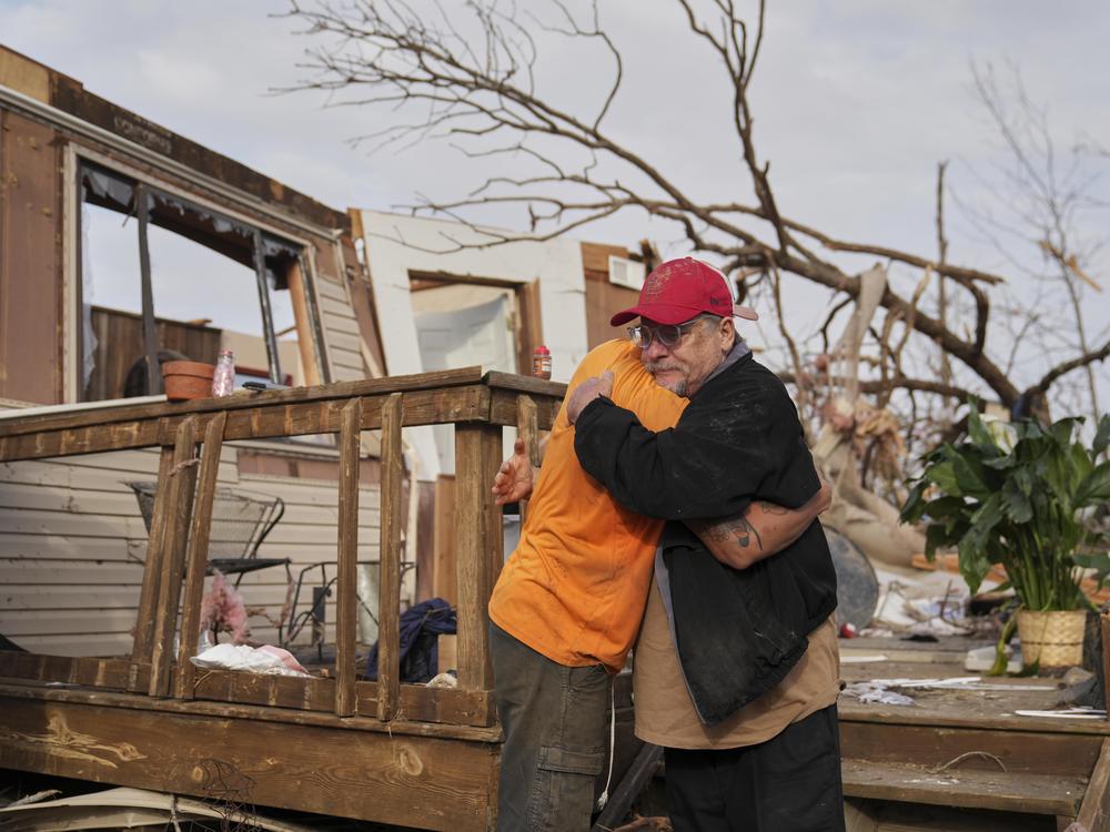 Tim Scott, right, gets a hug from friend Jorden Harris outside Scott's home he was inside when it was destroyed during a severe storm the evening before Saturday, March 15, 2025, in Wayne County, Mo.