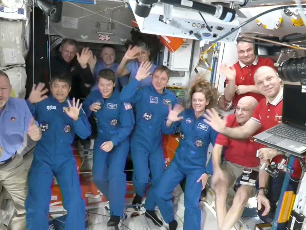 This image made from video by NASA shows astronauts waving after a four-person crew arrived at the International Space Station on Sunday, March 16.