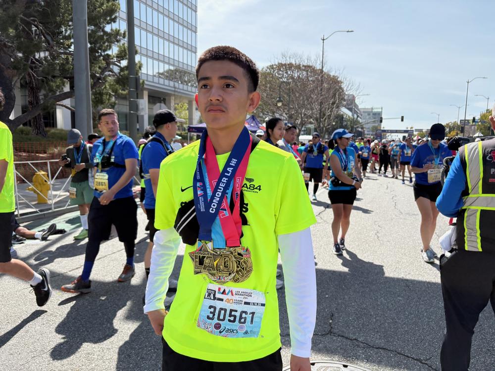 Abel Rivera wears his medals after finishing the LA Marathon on Sunday in Century City.