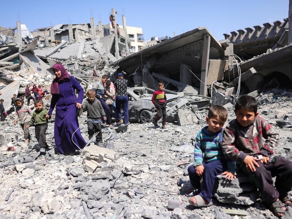 Children look on as people walk amid the rubble of a building destroyed in an overnight Israeli strike in Jabalia, in the northern Gaza Strip on Tuesday. Israel's deadly strikes on Gaza drew global condemnation, as it said it had 