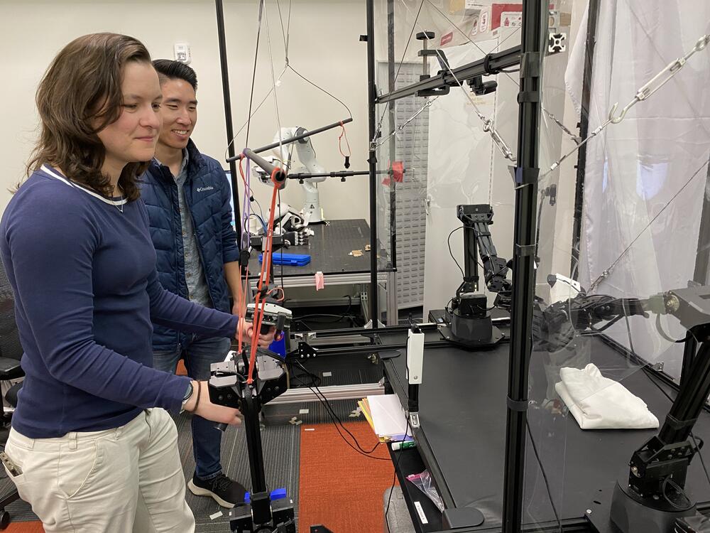 Chelsea Finn (left) and Moo Jin Kim conduct a demonstration with a robot at Stanford University.