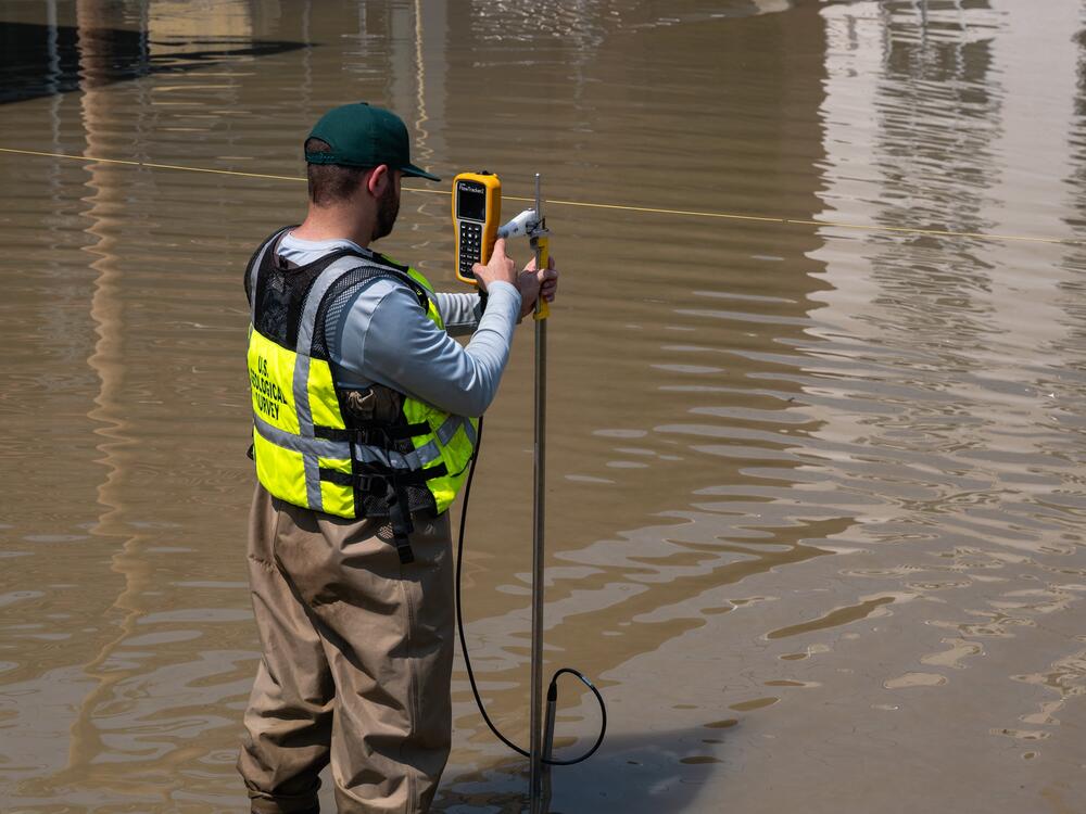 U.S. Geological Survey hydrographer Samuel Jacob measures the flooded Winooski River's discharge on July 11, 2023, in Montpelier, Vt.