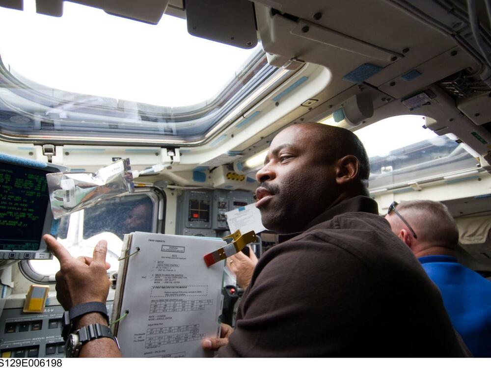 Astronauts Leland Melvin, STS-129 mission specialist, and Butch Wilmore, pilot, work on the aft flight deck of Space Shuttle Atlantis during flight day two activities on Nov. 17, 2009.