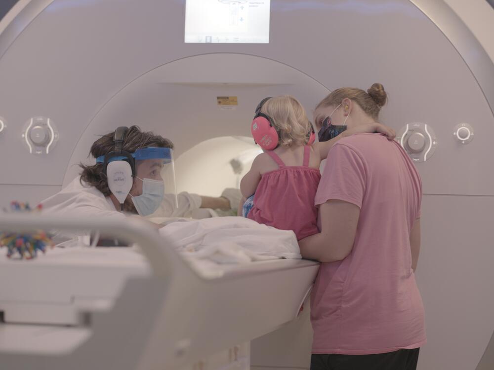 Yale cognitive neuroscientist Nick Turk-Browne works with a baby and parent during a brain scan.