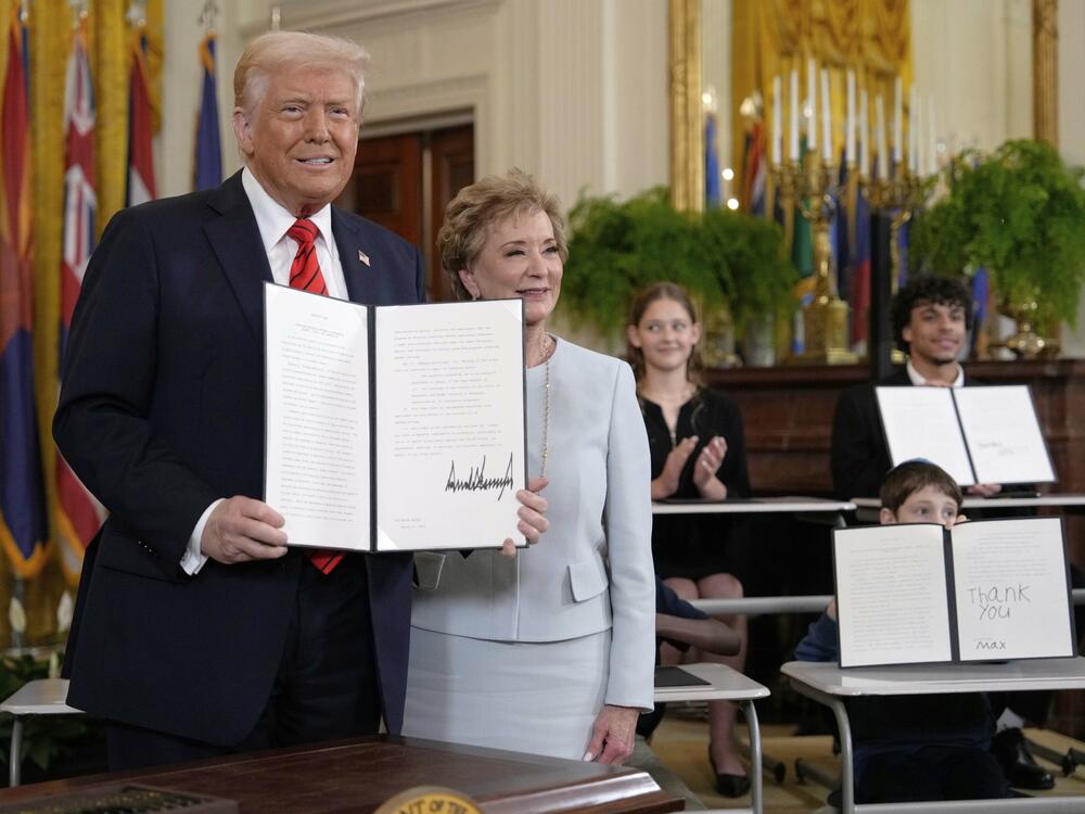 President Donald Trump holds up a signed executive order alongside Secretary of Education Linda McMahon in the East Room of the White House in Washington, Thursday, March 20, 2025.