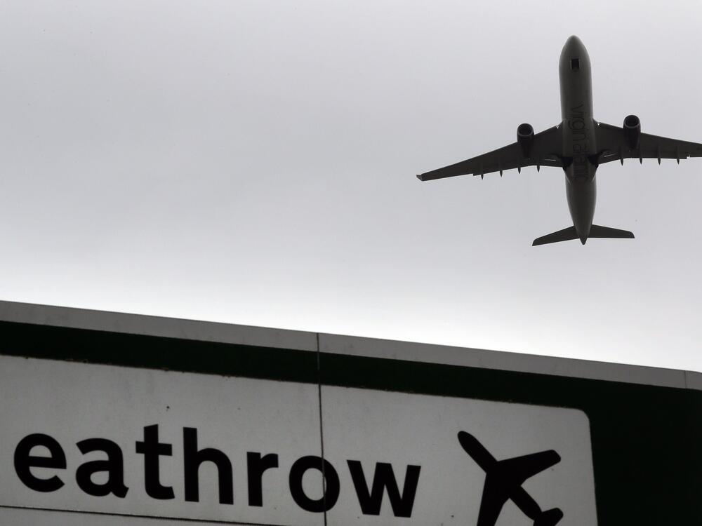 A plane takes off over a road sign near Heathrow Airport in London.