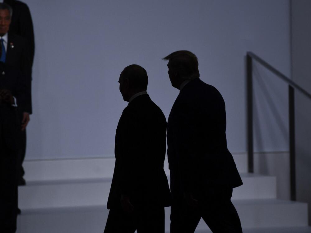 President Donald Trump (right) walks with Russia's President Vladimir Putin before taking a family photo at the G20 Summit in Osaka on June 28, 2019.
