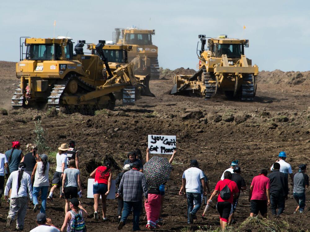 Native American protestors and their supporters are confronted by security during a demonstration against work being done for the Dakota Access Pipeline (DAPL) in North Dakota in 2016. Greenpeace, one of the groups protesting DAPL, was sued by the company building the pipeline. A jury has ordered Greenpeace to pay millions of dollars.