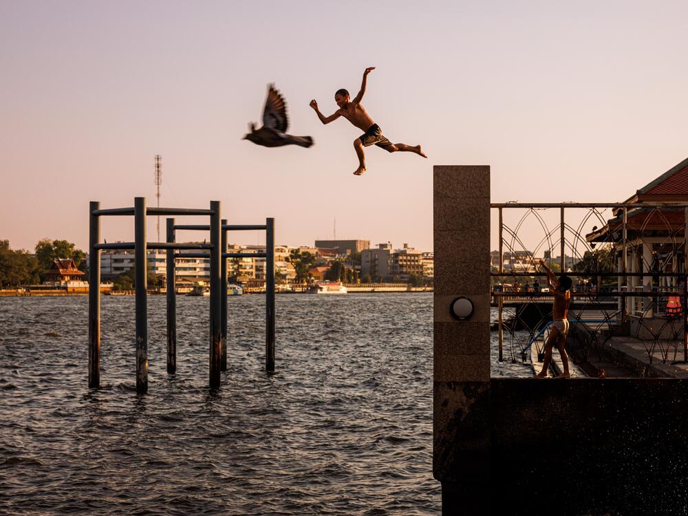 The boy and bird are, of course, not really flying together. But ... they are both airborne. The child is jumping into the Chao Phraya river in Bangkok, Thailand, during a heatwave in February 2024. Photographer Andre Malerba notes: 