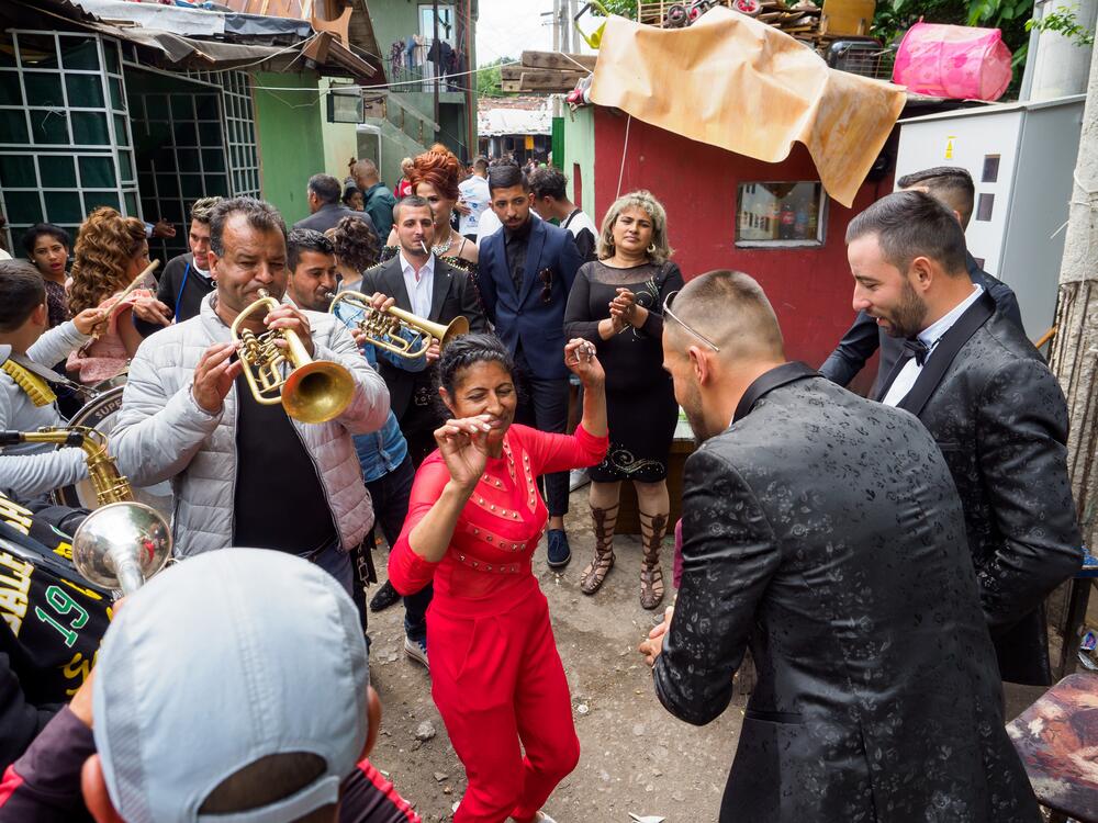 Members of the Roma community in Sofia, Bulgaria, celebrate at a wedding, with musicians entertaining the guests.